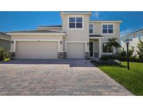 Charming two-story home featuring a paved driveway, a two-car garage, and manicured landscaping at 4322 Silo Port Ct, Lakewood Ranch, FL 34211