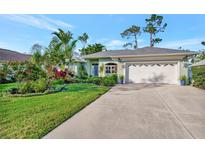 Charming single-story home with well-manicured lawn, lush landscaping, and a two-car garage at 7235 Rangi Dr, Sarasota, FL 34241
