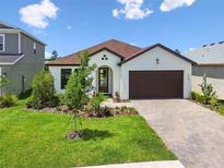 Charming single-story home featuring a well-manicured lawn, brick driveway, and an attached garage at 774 Hillshire Pl, Spring Hill, FL 34609