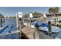 Dock with a boat lift and covered boat on a sunny day at 9612 Valencia Cv, Bradenton, FL 34210