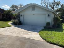 Single-story home with attached garage and landscaped yard at 7861 Pine Trace Dr # 7861, Sarasota, FL 34243