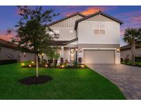 Two-story home with landscaped yard, at dusk at 3717 Savanna Palms Ct, Lakewood Ranch, FL 34211