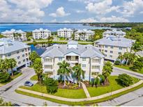 Aerial view of waterfront condo community with lush landscaping and a pond at 3412 79Th Street W Cir # 202, Bradenton, FL 34209