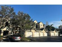Exterior view of condo building with garages and landscaping at 5146 Northridge Rd # 209, Sarasota, FL 34238