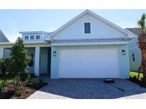 Charming, light blue single Gathering home with a pristine white garage door and paver driveway at 705 Anegada Ln, Sarasota, FL 34234