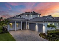 Two-story home with gray double-car garage and landscaped yard at 8175 Redonda Loop, Lakewood Ranch, FL 34202