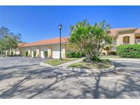 Condo building exterior showcasing multiple garages and lush landscaping at 7131 Boca Grove Pl # 202, Lakewood Ranch, FL 34202