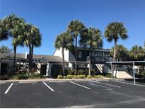 Condo complex featuring palm trees, ample parking, and well-maintained landscaping at 7234 Cloister Dr # 7234, Sarasota, FL 34231