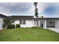 Front view of a villa with a carport and well-maintained lawn at 3961 Ashwood Ln # 44, Sarasota, FL 34232