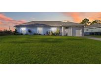 Charming light blue house with green lawn at 6771 Topeka Ln, North Port, FL 34291