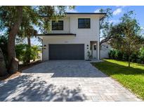 Modern two-story house with gray garage door and landscaping at 2318 Bay St, Sarasota, FL 34237
