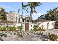Elegant home exterior with gated entry and lush landscaping at 8213 Midnight Pass Rd, Sarasota, FL 34242