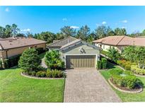 House exterior showcasing a two-car garage and well-manicured landscaping at 5016 Savona Run, Bradenton, FL 34211