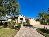 Charming home with a red tile roof, beautiful landscaping, and a brick paved driveway at 2921 Seasons Blvd, Sarasota, FL 34240