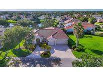 Inviting home with a manicured lawn and a paver driveway leading to a two-car garage at 2921 Seasons Blvd, Sarasota, FL 34240