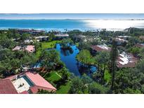 Aerial view of waterfront community with lush landscaping, pond, and bay access at 6466 Seagull Dr # 323, Bradenton, FL 34210