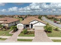 Aerial view of a single-story home with tile roof, landscaped yard, and paved driveway at 6741 Rookery Lake Dr, Bradenton, FL 34212