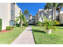 Condo building with walkway and lush tropical landscaping at 2209 Belleair Rd # C29, Clearwater, FL 33764