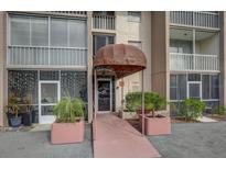 Condo building entrance with awning and landscaping at 519 Albee Farm Rd # 212, Venice, FL 34285