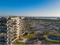 Beautiful aerial view showcasing the building near a beach, parking area, and decorative pond at 1055 Beach Rd # B-302, Sarasota, FL 34242
