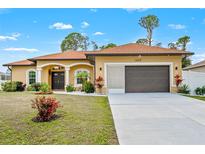 House exterior featuring a two-car garage and well-manicured lawn at 1503 Evangelina Ln, North Port, FL 34286