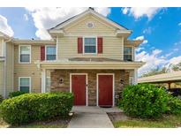 Two-story tan home with red doors and landscaping at 4850 51St W St # 5101, Bradenton, FL 34210