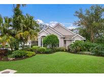 Beautiful house exterior with lush landscaping and a manicured lawn at 8223 Regents Ct, University Park, FL 34201