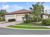 Two-car garage home with attractive landscaping and brick paver driveway at 9869 Haze Dr, Venice, FL 34292