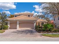 Charming two-story home with a three-car garage, tile roof, and well-maintained landscaping at 650 Crane Prairie Way, Osprey, FL 34229