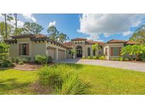 Mediterranean-style home with a three-car garage and lush landscaping at 9291 Swaying Branch Rd, Sarasota, FL 34241
