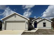 New construction home with a two-car garage and neutral exterior at 890 Indus Rd, Venice, FL 34293