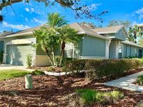 Charming one-story home with lush landscaping, mature palm trees, and a well-manicured lawn at 10444 48Th E Ct, Parrish, FL 34219