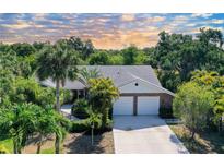 Two-story house with two-car garage, lush landscaping, and palm trees at 4589 Trails Dr, Sarasota, FL 34232