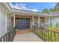 Charming front entrance with a black double door, brick facade, and well-maintained landscaping at 4589 Trails Dr, Sarasota, FL 34232