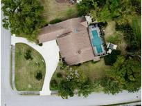 Birds-eye view of the home with well manicured lawn, long driveway, and screened in pool at 7317 Crape Myrtle Way, Sarasota, FL 34241