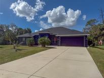 Single-Gathering home with a two-car garage and palm trees at 1661 Atwater Dr, North Port, FL 34288
