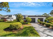 Front view of two-story townhome with attached two-car garage and landscaped yard at 3119 Heatherwood Ln, Sarasota, FL 34235
