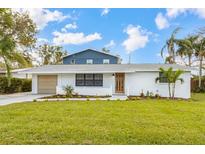 Charming updated home with a two-toned exterior, modern door, and manicured lawn at 5321 13Th Avenue W Dr, Bradenton, FL 34209