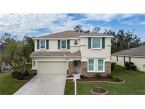 Two-story house with beige exterior, stone accents, and a two-car garage at 5331 98Th E Ave, Parrish, FL 34219