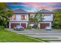 Stunning modern home with a spacious driveway, lush landscaping, and a sleek, two-car garage at 5861 Gulf Of Mexico Dr, Longboat Key, FL 34228