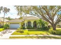 Beautiful yellow home with lush landscaping and a large tree at 7506 Eaton Ct, University Park, FL 34201