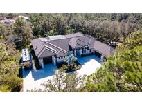 Stunning aerial view of custom estate home featuring a modern design, circular driveway, and lush landscaping at 9260 Swaying Branch Rd, Sarasota, FL 34241