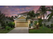 Charming two-story home with a well-manicured front yard, two car garage, and inviting blue front door at 12224 Longview Lake Cir, Bradenton, FL 34211