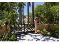 Ornate gate opens to a beautiful waterfront property with lush landscaping at 4511 Bay Shore Rd, Sarasota, FL 34234