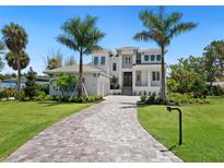 Two-story home with a large driveway and landscaped yard at 5910 Gulf Of Mexico Dr, Longboat Key, FL 34228
