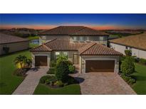Two-story home with a tile roof, two-car garage, and landscaped yard at 6771 Wild Lake Ter, Bradenton, FL 34212
