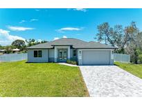 New construction home with gray exterior, gray paved driveway and landscaped lawn at 1010 Acadia Rd, Venice, FL 34293