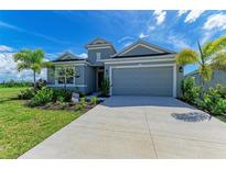 New construction home with gray exterior and a two-car garage at 12389 Cedar Pass Trl, Parrish, FL 34219