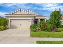 Tan house with two-car garage, landscaping, and a welcoming front yard at 12741 Coastal Breeze Way, Bradenton, FL 34211