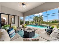 Relaxing screened patio with a pool view, comfortable seating, and a cozy fire pit at 17802 Eastbrook Ter, Lakewood Ranch, FL 34202